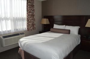 una camera d'albergo con un grande letto e una finestra di Cobble Creek Lodge a Maple Creek