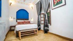 una camera da letto con un letto con testiera blu di Riad le dromadaire bleu by Weekome a Marrakech Altre 37 foto
