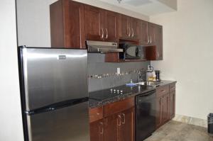 a kitchen with a stainless steel refrigerator and wooden cabinets at Cobble Creek Lodge in Maple Creek