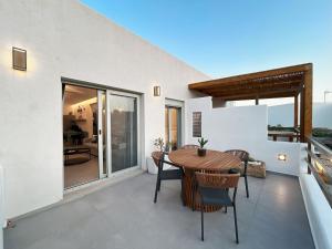 a dining room with a table and chairs on a balcony at Aura Suites in Leipsoi