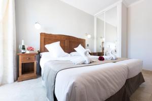 a bedroom with a large bed with two white towels at Hotel Toboso Chaparil in Nerja
