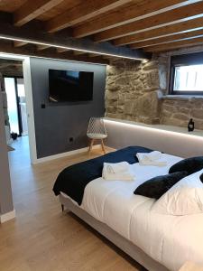 a bedroom with a bed and a wall with a tv at Casa vacacional San Miguel in Maside