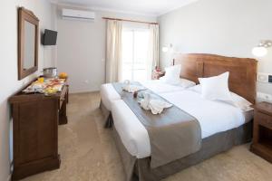 a bedroom with a large bed with towels on it at Hotel Toboso Chaparil in Nerja