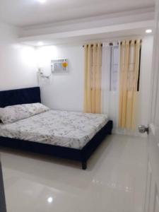 ein kleines Schlafzimmer mit einem Bett und einem Fenster in der Unterkunft Transient Staycations home in Balibago