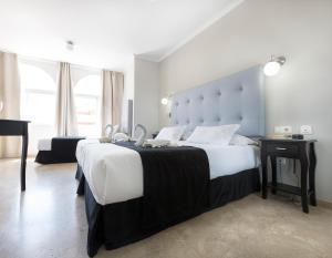 a bedroom with a large bed with a large headboard at Hotel Toboso Chaparil in Nerja