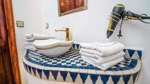 un bagno con lavandino e asciugamani su un bancone di Riad le dromadaire bleu by Weekome a Marrakech