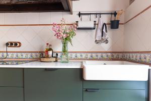 a kitchen with a vase of flowers on a counter at Casa La Franca in Ríocorvo +34 photos