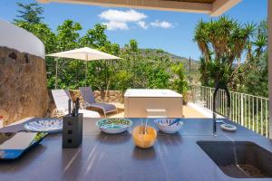 a patio with a table and an umbrella on a deck at Dolceterra Eolian Villas in Lipari