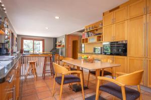 a kitchen with wooden cabinets and a table and chairs at Can Toni Gat in Bunyola