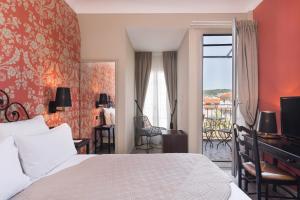 a hotel room with a bed and a balcony at Hotel Le Grimaldi by Happyculture in Nice