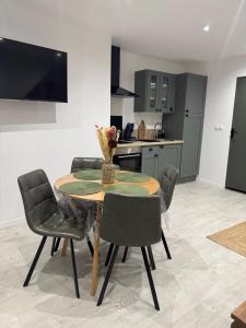 a dining room with a table and chairs and a kitchen at Le Chti nid d'Opale in Boulogne-sur-Mer