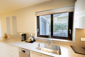 a kitchen with a sink and a window at Villy Luxury Home by the Sea 1 in Ayiá