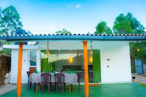 een tafel en stoelen op het terras van een huis bij Lina Eco Cottage - Ella in Ella