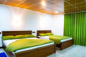 twee bedden in een kamer met groene gordijnen bij Lina Eco Cottage - Ella in Ella +29 foto's