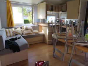 un salon avec un canapé et une table et une cuisine dans l'établissement Mobil home dans un camping 5 à Deauville, à Saint-Arnoult