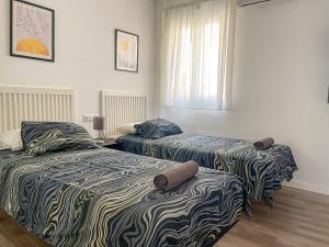 sypialnia z dwoma łóżkami i oknem w obiekcie DV Properties Residencial Apartment #P4F2 w Maladze +10 zdjęć