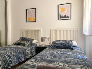 dwa łóżka ustawione obok siebie w sypialni w obiekcie DV Properties Residencial Apartment #P4F2 w Maladze