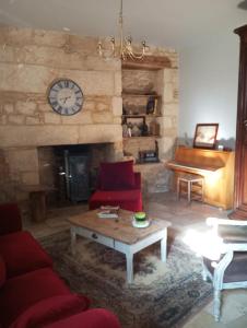 a living room with a couch and a fireplace with a clock at Napoléon in Montignac