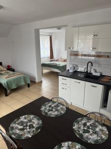 a kitchen with a table and chairs in a room at Willa Aleksander in Rowy