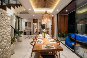 ein Esszimmer mit einem langen Holztisch und Stühlen in der Unterkunft Villa Ines by BaliSuperHost in Mengwi