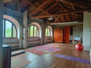 a large living room with a wooden floor and windows at Casetta nella Città Invisibile in Piana Crixia