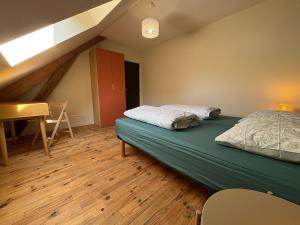 a bedroom with two beds and a desk in a attic at Potentille - Village center apartment in Saint-Martin-de-Bréthencourt