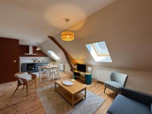 a living room with a couch and a table at Potentille - Village center apartment in Saint-Martin-de-Bréthencourt