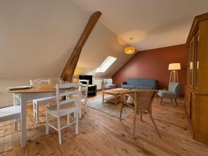 a living room with a table and chairs and a couch at Potentille - Village center apartment in Saint-Martin-de-Bréthencourt +10 photos