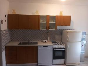 a kitchen with a sink and a stove and a refrigerator at Apartment Josić in Obrovac