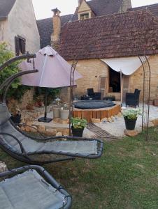 a backyard with a patio with an umbrella at Napoléon in Montignac