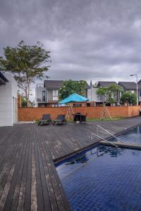 una piscina con bancos y una sombrilla azul en Villa Darmadi, en Tanah Lot