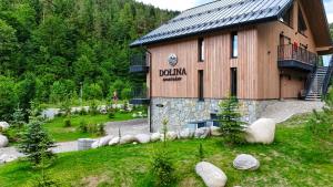 a building with a sign on the side of it at Apartmány Dolina in Belá