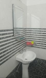 ein Badezimmer mit Waschbecken und Spiegel in der Unterkunft Chandra Leelas Ashirwad Cottage in Mukteswar