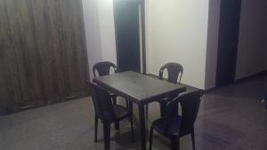 einen Esstisch mit 4 Stühlen und einem Holztisch in der Unterkunft Chandra Leelas Ashirwad Cottage in Mukteswar + 7 Fotos