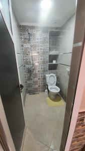 a bathroom with a toilet in a room with tiles at wunderschöne Wohnung in Imi Ouaddar in Imi Ouaddar