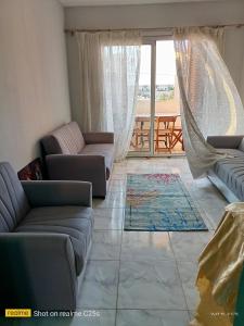 d'un salon avec canapés et vue sur le patio. dans l'établissement الصيف احلى فى الساحل, à El Alamein