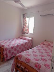 une chambre avec deux lits et une fenêtre dans l'établissement الصيف احلى فى الساحل, à El Alamein