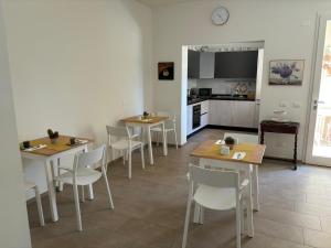 una sala da pranzo con tavoli e sedie e una cucina di Conte Camillo a Cotignola