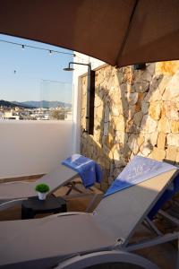 a room with two chairs and a stone wall at Hotel Boutique Casa Veracruz in Estepona