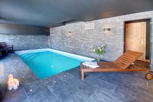 a swimming pool with a chaise lounge and a swimming pool at Chalet de Claude in Morzine - by EMERALD STAY in Morzine