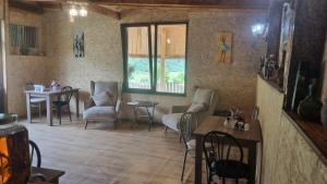 a living room with chairs and a table and a window at Maizer Qaldani Guesthouse in Chvabiani