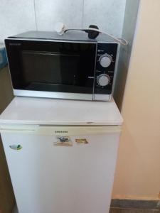 a microwave sitting on top of a refrigerator at Ayo's Vacation Home in Thika