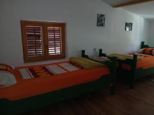 een slaapkamer met twee bedden en een raam bij Apartmenthaus Kornatiblick in Tisno +12 foto's