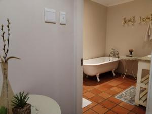 a bathroom with a bath tub and a table at The Glades Cottage in Balgowan