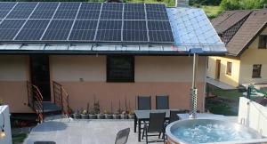 a house with a tub with solar panels on the roof at Penzion Ján in Habovka