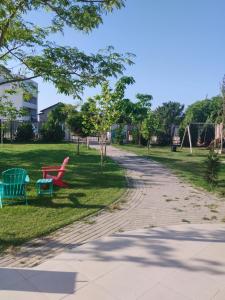 a park with two colorful chairs on the grass at Golful Lebedelor in Eforie Sud +17 photos