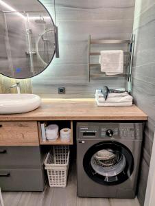 Un baño con una lavadora debajo del lavabo. en Апартаменты на Тохтарова, en Öskemen