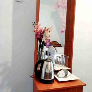 a mirror on a table with a tea kettle and flowers at Dambulla Sun Vsh Holiday in Dambulla +40 photos
