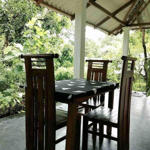 a table and two chairs on a porch at Dambulla Sun Vsh Holiday in Dambulla