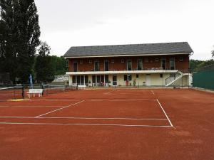 a building with two tennis courts on a tennis court at Cappello Vendégház in Baja